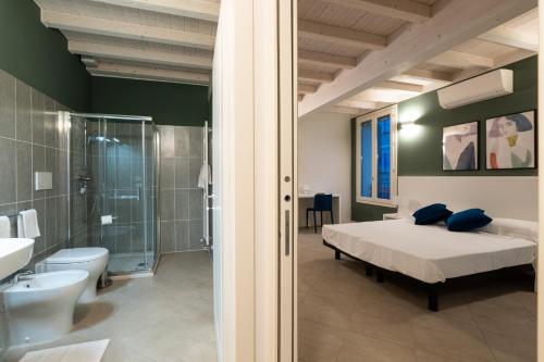 Un dormitorio con una cama, una ducha y un inodoro. en Le Stanze di Gianmarmo - Via Marsala, en Mirandola
