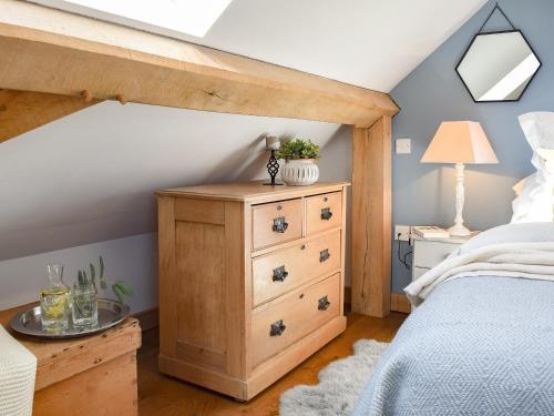 a bedroom with a bed with a wooden dresser and a bed sqor at Shepherds Loft in Benson