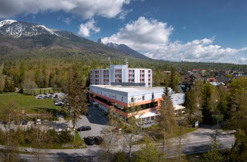 uma vista aérea de um edifício em frente a uma montanha em Atrium Hotel - Family friendly em Nový Smokovec