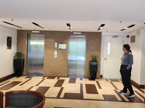 a woman standing in a hallway in a building at JOH & BONG CONDO UNIT RENTAL-BORACAY OCEANWAY RESIDENCES in Boracay