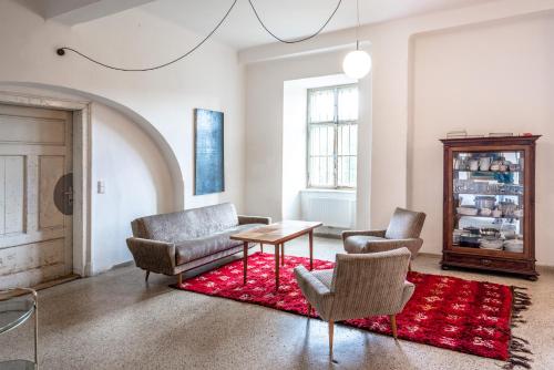 a living room with chairs and a table and a red rug at Schloss Hornegg in Preding
