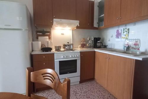 uma cozinha com armários de madeira e um forno de fogão branco em SeaShell apartment Sea View, Castle View 200metres from the Beach em Sitia