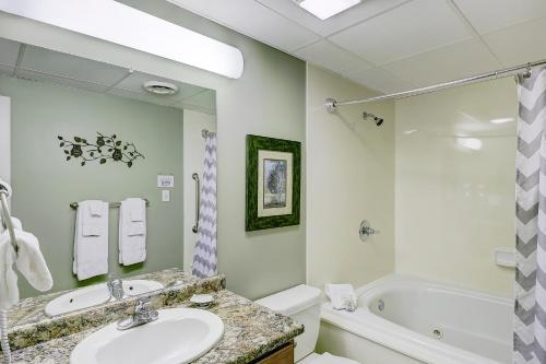 La salle de bains est pourvue d'un lavabo, d'une baignoire et de toilettes. dans l'établissement Linger Longer Whispering Pines 231, à Pigeon Forge