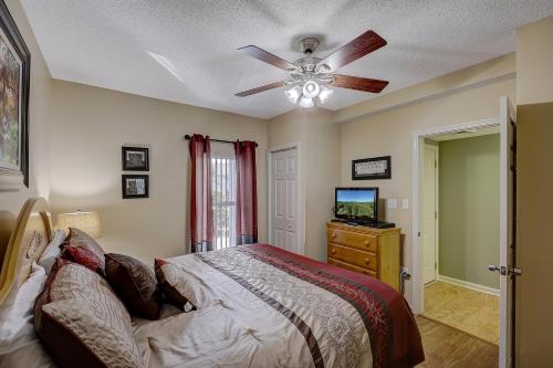 - une chambre avec un lit et un ventilateur de plafond dans l'établissement Linger Longer Whispering Pines 231, à Pigeon Forge