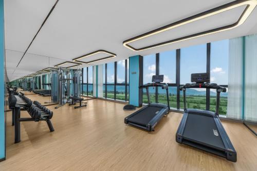 a gym with treadmills and ellipticals and windows at Holiday Inn Express Jiangmen Yinhu Bay, an IHG Hotel in Jiangmen