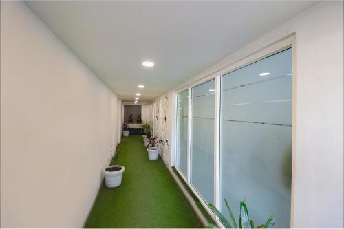 a hallway with a green floor in a building at FabExpress La Serene - Near Yamuna Sports Complex in New Delhi