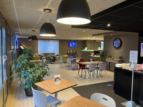 a restaurant with tables and chairs in a cafeteria at Hôtel Campanile Orléans Nord - Saran in Saran