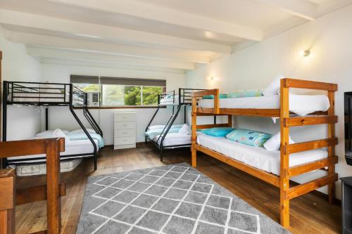 Habitación con 3 literas y alfombra. en The Anchorage Cottage, en McCrae