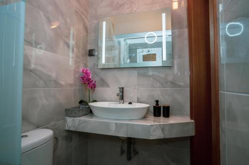 a bathroom with a sink and a mirror at Seashell Luxury Apartment in Nikiti