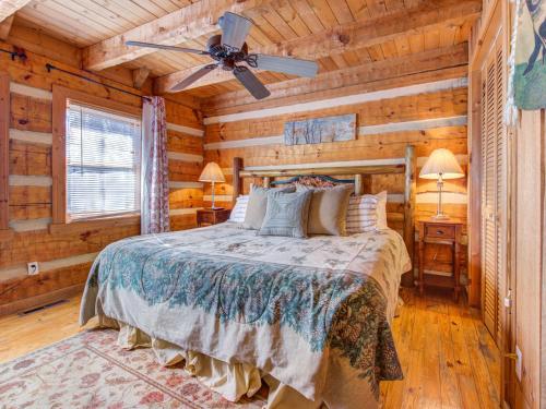 a bedroom with a bed in a log cabin at Bear Cave Haus, 2 Bedrooms, Fireplace, Hot Tub, Pool Table, WiFi, Sleeps 8 in Gatlinburg