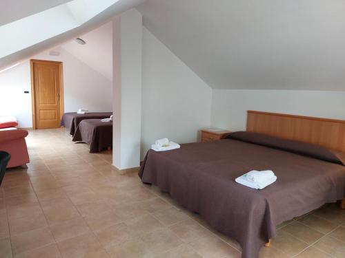 a hotel room with two beds and a couch at Hospedería Externa del Monasterio in Samos
