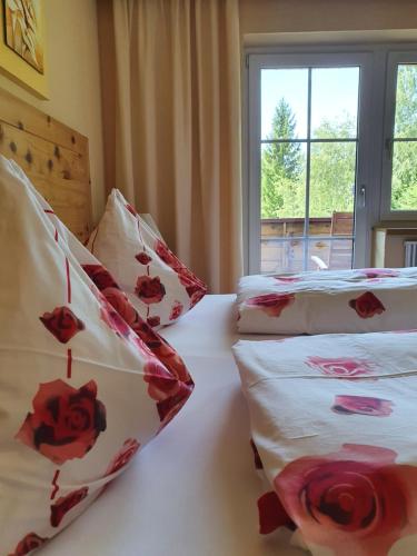 a bedroom with two beds with red and white pillows at Romantik Pension Lehrberg in Sankt Jakob in Haus