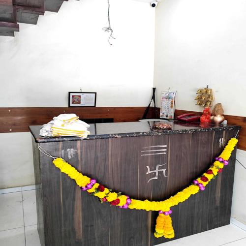 a reception desk with a yellow and purple garland at Hotel Borivali Executive - Near Borivali Railway Station in Mumbai