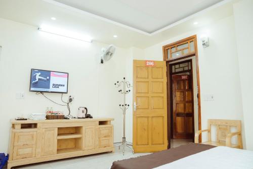 um quarto com uma cama e uma televisão na parede em Hoan Hao Hotel em Ha Giang