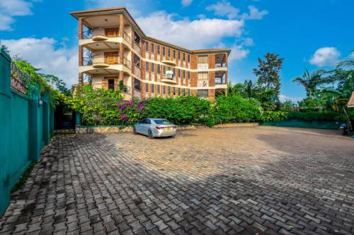 恩德培的住宿－Victoria Breeze Suites, Entebbe，停在大楼前的汽车