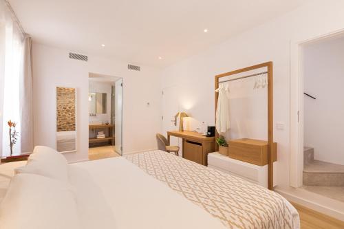 a bedroom with a bed and a desk with a mirror at Petit Palau Alcudia - Adults Only in Alcudia