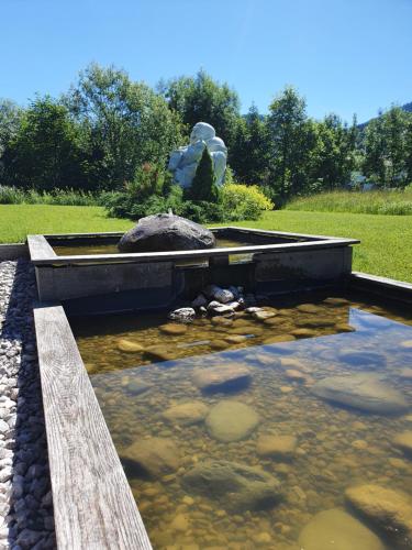 a pool of water with a statue in the middle at Romantik Pension Lehrberg in Sankt Jakob in Haus