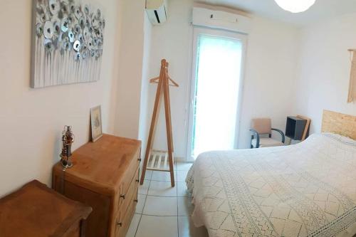 um quarto com uma cama e um tripé de madeira em Au Coeur du Var ! Bienvenue à Draguignan ! em Draguignan