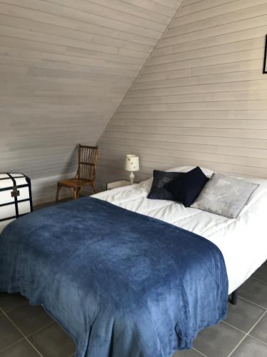- une chambre avec un lit doté d'une couverture bleue dans l'établissement La Metairina, à Pénestin