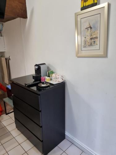 a black dresser in a room with a picture on the wall at AUTEUIL PASSY in Paris