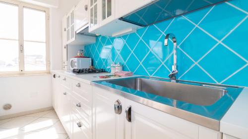 cocina con fregadero y azulejos azules en la pared en Welcomely - Casa Dei Catalani, en Torre Grande
