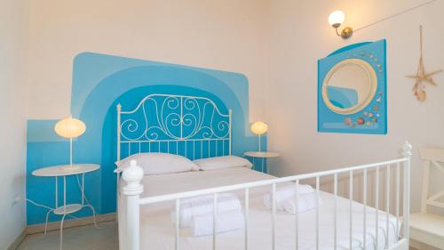 1 dormitorio con 1 cama con cabecero azul en Welcomely - Casa Dei Catalani, en Torre Grande
