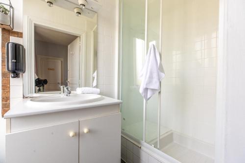 uma casa de banho com um lavatório e um chuveiro em F3 Av république avec garage (c) em Clermont-Ferrand