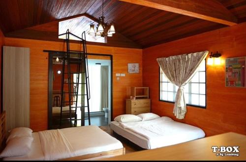 a bedroom with two beds and a ladder in it at T-Box Sungai Lembing in Sungai Lembing