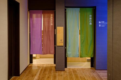 uma fila de portas com diferentes cortinas coloridas em Tosei Hotel Cocone Kamakura em Kamakura