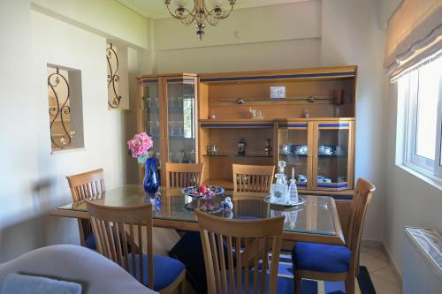 a dining room with a glass table and chairs at Loutraki view in Loutraki
