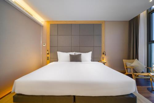 a large white bed in a hotel room at Estrella Boutique Hotel in Da Nang