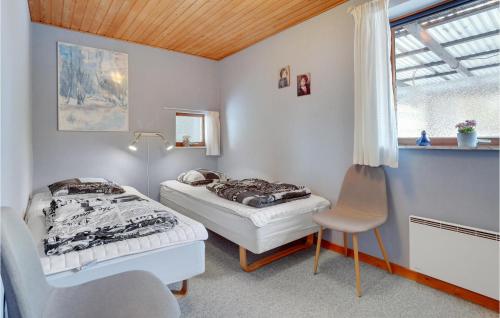 una camera con due letti e una sedia di 3 Bedroom Cozy Home In Rdby a Rødby
