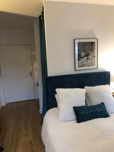 une chambre avec un lit avec une tête de lit bleue dans l'établissement Le studio d'Eva, à Honfleur