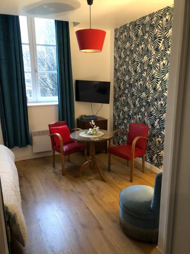 a room with a table and chairs and a tv at Le studio d'Eva in Honfleur