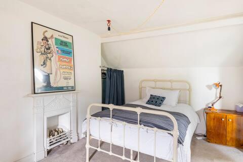 a bedroom with a white bed and a fireplace at Tŷ Selah, Rugby Ave, Neath in Neath