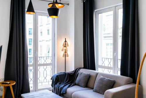 un soggiorno con divano e una grande finestra di Precioso Apartamento en el Centro de Granada. a Granada