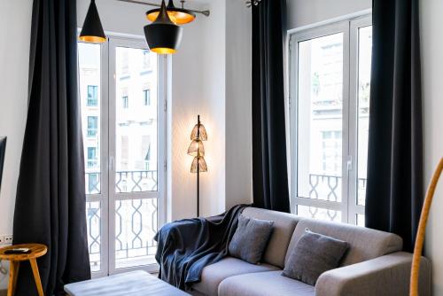 a living room with a couch and a large window at Precioso Apartamento en el Centro de Granada. in Granada