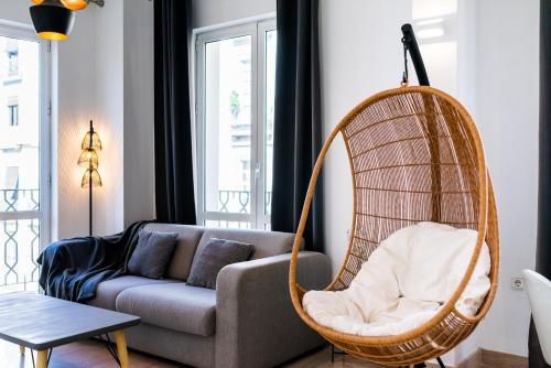 salon z kanapą i wiszącym krzesłem w obiekcie Precioso Apartamento en el Centro de Granada. w Grenadzie
