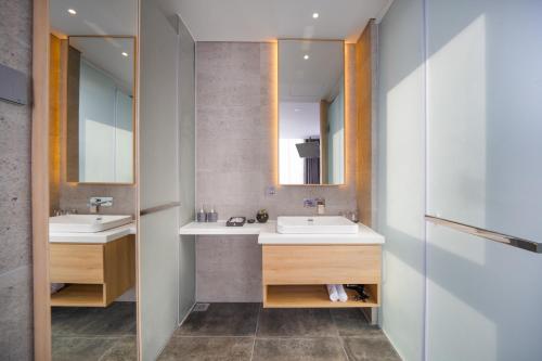 a bathroom with two sinks and a mirror at Estrella Boutique Hotel in Da Nang