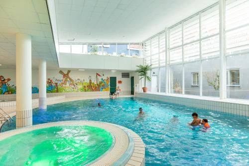 een zwembad in een gebouw met mensen in het water bij Marinapark Volendam in Volendam