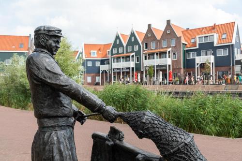 a statue of a man holding a child at Marinapark Volendam in Volendam