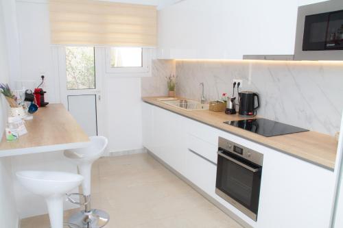 uma cozinha branca com um lavatório e um fogão em Acropolis Luxurious Legacy em Atenas
