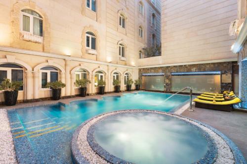 an indoor pool in a building with a swimming pool at Grand Regency Doha, Trademark Collection by Wyndham in Doha