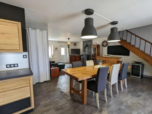 kuchnia i jadalnia z drewnianym stołem i krzesłami w obiekcie La talonnière, maison de village avec terrasse et 3 chambres w mieście Messas