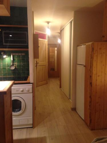 a kitchen with a white stove top oven next to a refrigerator at T2ideal vue imprenable sur la guisane in La Salle Les Alpes
