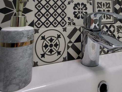 a bathroom sink with a toothbrush holder and a faucet at www SanMartinPlaza es En el corazón del casco histórico in León