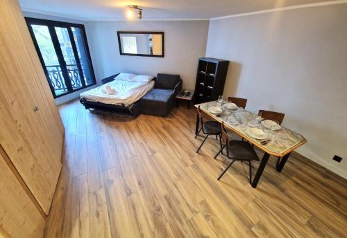 - un salon avec un lit et une table avec des chaises dans l'établissement Base Camp Chamonix Vue Mont Blanc Centre Ville, à Chamonix-Mont-Blanc