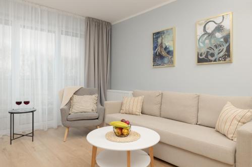- un salon avec un canapé, une table et une chaise dans l'établissement Wellness Resort & SPA Apartments Dziwnów Riverfront by Renters, à Dziwnów