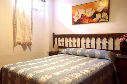 een slaapkamer met een bed en een schilderij aan de muur bij Casa Aguacate in Taramay