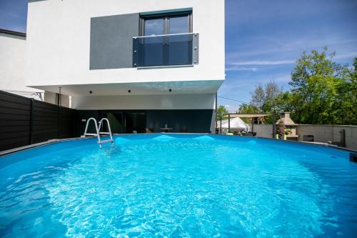 a swimming pool in front of a house at Villa Veroniq in Županje